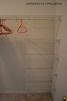 an empty closet with clothes hanging on the rack and two hangers in front of it