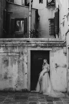 black and white photograph of woman in front of building