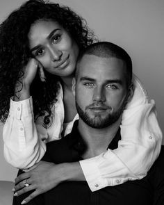 a man and woman posing for a black and white photo with their arms around each other