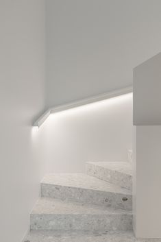 an empty room with white walls and marble steps