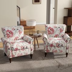 a living room with two chairs and a coffee table in front of a mirror on the wall