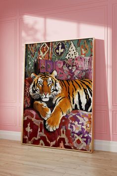 a large tiger laying on top of a couch in front of a pink painted wall