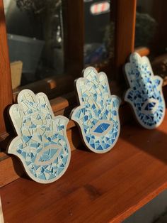 three small hand - shaped dishes sitting on top of a window sill