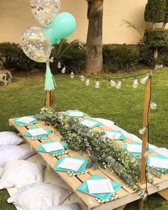 a table set up with plates and balloons