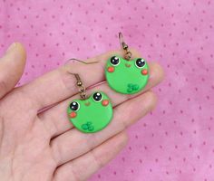 Hi CutiePie,  We're funny frogs earrings. We're earrings created from polymer clay without using any molds and completely handmade. We can be a funny gift for people of all ages. We'll always cheers You up and will bring a smile on your face.Our dimensions are:Length 0.8" ( or 2 cm. )Width 1" ( or 2.5 cm. )❀We come in a pretty box but please note in the event that several items are purchased all of us will ship in one box.❀ Because we're made by hand, we may differ slightly than shown on the pic Cute Green Hand Painted Jewelry, Kawaii Polymer Clay Earrings For Gift, Handmade Polymer Clay Kawaii Jewelry, Handmade Kawaii Polymer Clay Jewelry, Fun Polymer Clay Nickel-free Jewelry, Green Resin Fun Earrings, Fun Nickel-free Polymer Clay Jewelry, Green Handmade Fun Earrings, Quirky Handmade Resin Jewelry