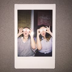 two girls looking through binoculars at something