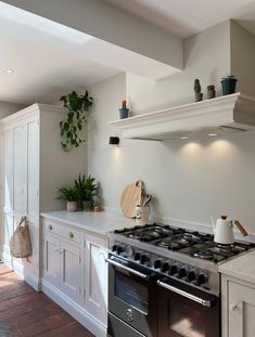 a stove top oven sitting inside of a kitchen next to white cabinets and counter tops