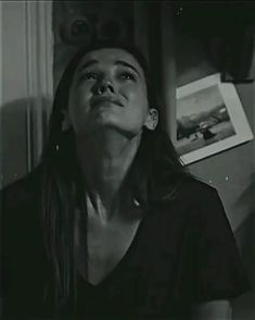 a black and white photo of a woman looking up in the air with her eyes closed