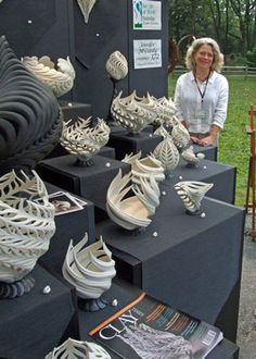 a woman is standing next to some art pieces