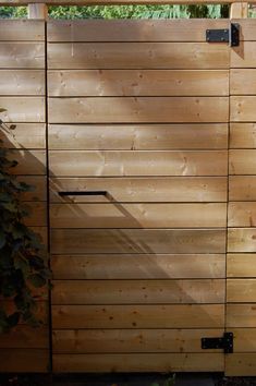 a wooden fence with metal handles on the top and bottom panels, along with a planter