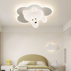 a bed room with a neatly made bed and a teddy bear on the headboard