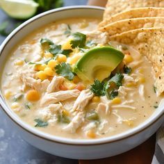 a bowl of chicken tortilla soup with corn and avocado