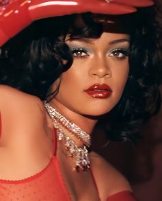 a close up of a woman wearing a red dress and hat with diamond jewelry on her neck