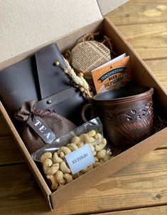 a box filled with nuts and other items on top of a wooden table next to a cup