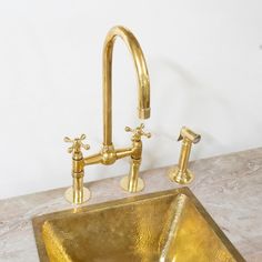 a gold sink with two faucets on it