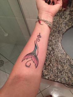 a woman's arm with a mermaid tattoo on it