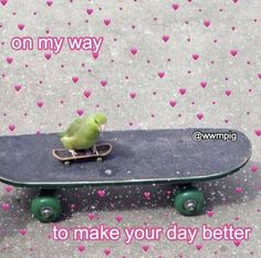 a green bird sitting on top of a skateboard with hearts all over the ground