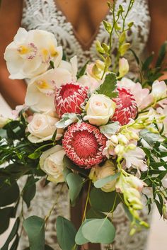 a woman holding a bouquet of flowers in her hands