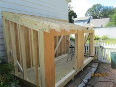 a house being built in the backyard with wood framing on the floor and siding around it