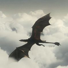 a large black dragon flying through the clouds