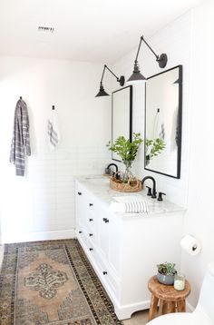 a white bathroom with two sinks and mirrors on the wall next to a bathtub