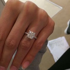 a woman's hand with a diamond ring on it