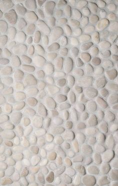 a wall made out of rocks with white paint on the top and bottom half of it