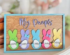 a wooden sign that says, my peeps are painted with colorful easter bunnies