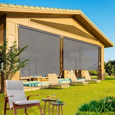 an outdoor area with lawn chairs, tables and large windows covered in shades for shade