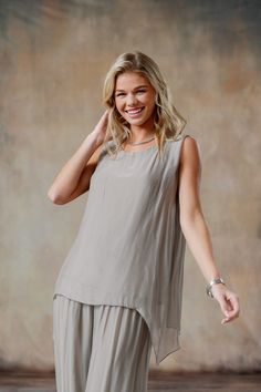 The sleeveless Marianna Silk Top showcases elegant silk layers and a flattering asymmetrical hemline, designed to wear with your favorite jeans or pants. Pair with our Madelyn Silk Pants for a chic head-to-toe look. One of our Signature Styles, part of our mix-and-match Italian Silk assortment. Classic fit. One size fits most. Boat neck sleeveless top, comfortable knit jersey lining, asymmetrical silk overlay. 100% Italian silk body, viscose lining. Hand wash, lay flat or hang to dry. Made in It Elegant Asymmetrical Summer Tank Top, Elegant Asymmetrical Hem Tank Top For Spring, Chic Linen Blouse For Layering, Elegant Linen Tops For Layering, Summer Layering Blouse With Asymmetrical Hem, Elegant Asymmetrical Hem Tank Top For Summer, Layered Sleeveless Tops, Chic Summer Top With Overlay, Chic Summer Tops With Overlay