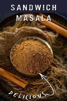 a bowl filled with masala next to two cinnamon sticks