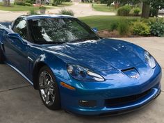 a blue sports car parked in front of a house