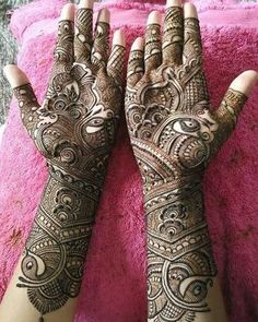 two hands with henna tattoos on them