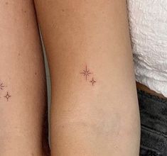 two people with small tattoos on their legs, one is holding the other's arm