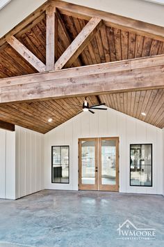 an empty room with two double doors and wood beams on the ceiling is shown in this image