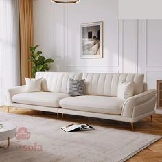 a living room with white couches and pillows on top of the rug in front of a large window