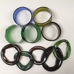 several different colored rings are arranged in a circle on a white surface with black and green accents