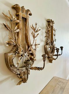 two wall sconces mounted to the side of a wall next to a wooden table