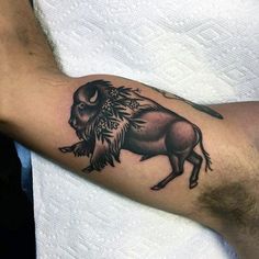 a man with a buffalo tattoo on his arm