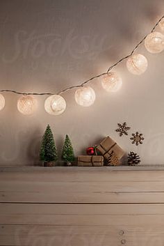 christmas lights are hanging on the wall above a dresser