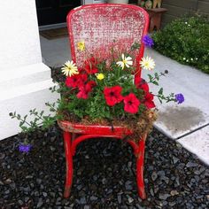 a red chair with flowers growing out of it