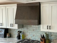 a stove top oven sitting inside of a kitchen next to white cabinets and counter tops