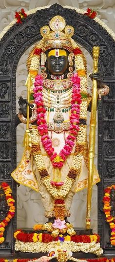 the statue is decorated with flowers and garlands on it's head, surrounded by other decorations