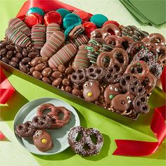 a tray filled with lots of chocolate covered pretzels next to cookies and candy