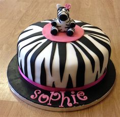 a zebra themed cake with pink ribbon around the top and name sophiie on it