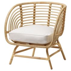 a wicker chair with a white pillow on the seat and back cushion in front of it