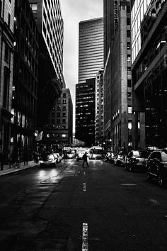 black and white photograph of city street with tall buildings