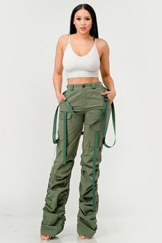 This distinct fashion choice merges the practicality of traditional utility wear with a touch of contemporary finesse. The pants are an ode to the functional attributes of cargo garments, designed to be robust with ample pocket space for practical use. The ruched detailing along the legs introduces a unique aesthetic twist, creating a gathered, textured effect that adds visual interest and a flair of modern sophistication. The inclusion of sleek, tonal belt straps further accentuates the waistli High Waist Green Parachute Pants With Multiple Pockets, Spring Combat Pants With Pockets, Spring Combat Cargo Pants, Spring Cotton Combat Cargo Pants, Spring Combat Cotton Cargo Pants, Spring Combat Cotton Pants, Spring Techwear Pants With Cargo Pockets, Khaki Techwear Bottoms With Cargo Style, Khaki High Waist Cargo Parachute Pants