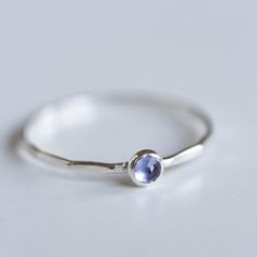 Tiny skinny stackable ring with beautiful Tanzanite stone. Its blue color with a shade of purple is fascinating.The ring is made with a skinny band, which allows you to create mind-blowing stacking sets! The ring is 0,8-0,9 mm thick and looks very dainty on the finger. Choose the cut of the stone (smooth or rose cut) and material for the ring (sterling silver or 9k gold).If you want to change the ring band design or get a custom ring or ring sets, feel free to contact me.You can order a ring of Dainty Solitaire Sapphire Ring, Adjustable Dainty Stackable Rings With Bezel Setting, Minimalist Sapphire Ring With Bezel Setting For Everyday, Sterling Silver Birthstone Ring For Everyday, Everyday Sterling Silver Birthstone Ring With Gemstone, Dainty Midi Rings With Bezel Setting, Dainty Stackable Sapphire Ring For Anniversary, Dainty Stackable Crystal Toe Ring, Minimalist Adjustable Sapphire Ring