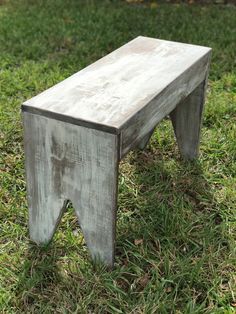 a wooden bench sitting on top of a lush green field